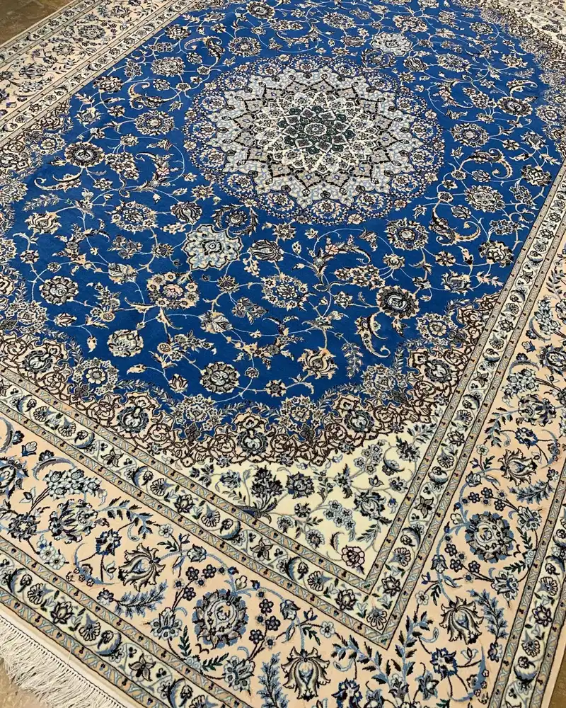 Tapis persan d’Ispahan noué main — Grand médaillon floral bleu royal et ivoire — 257 × 356 cm — vue en angle