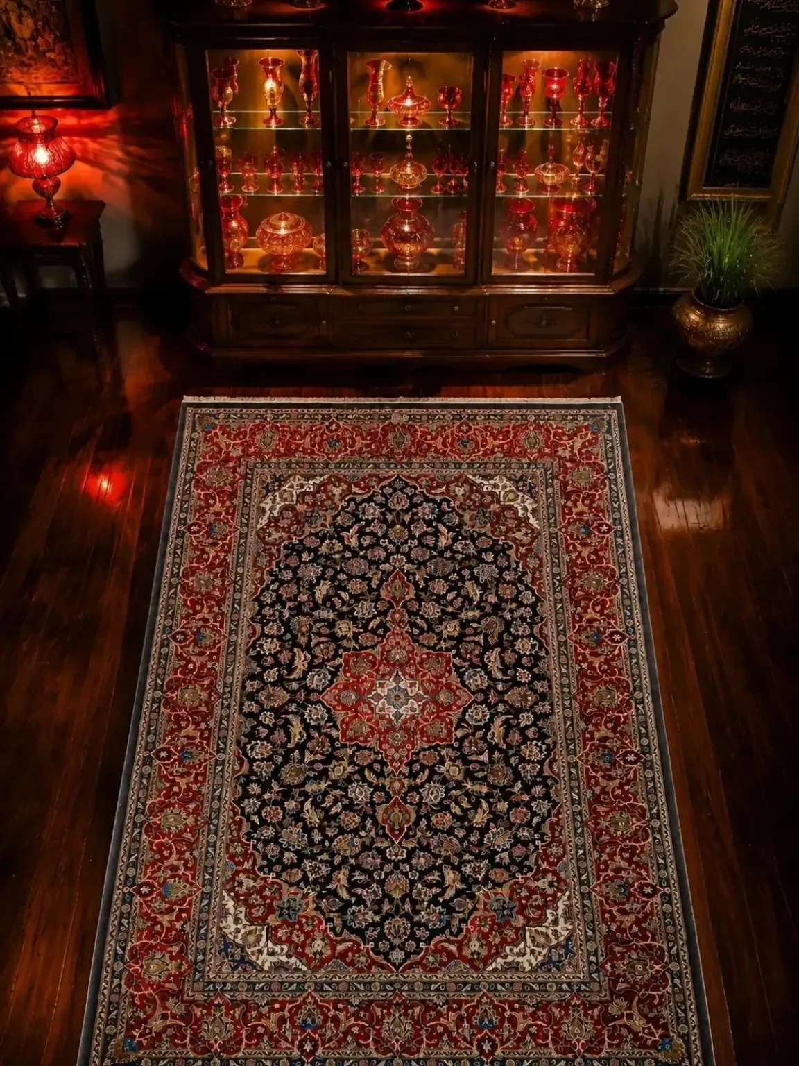 Persian Lachak Toranj Kashan rug displayed in a traditional dark-wood interior with illuminated red glassware