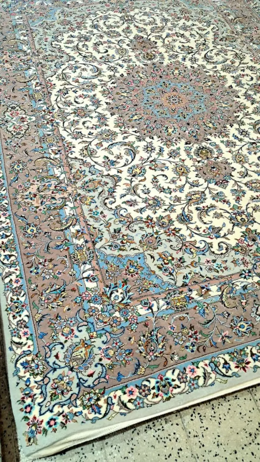 Detailed angled view of the silk floral motifs and medallion on Sacred Lachak Toranj Kashan carpet