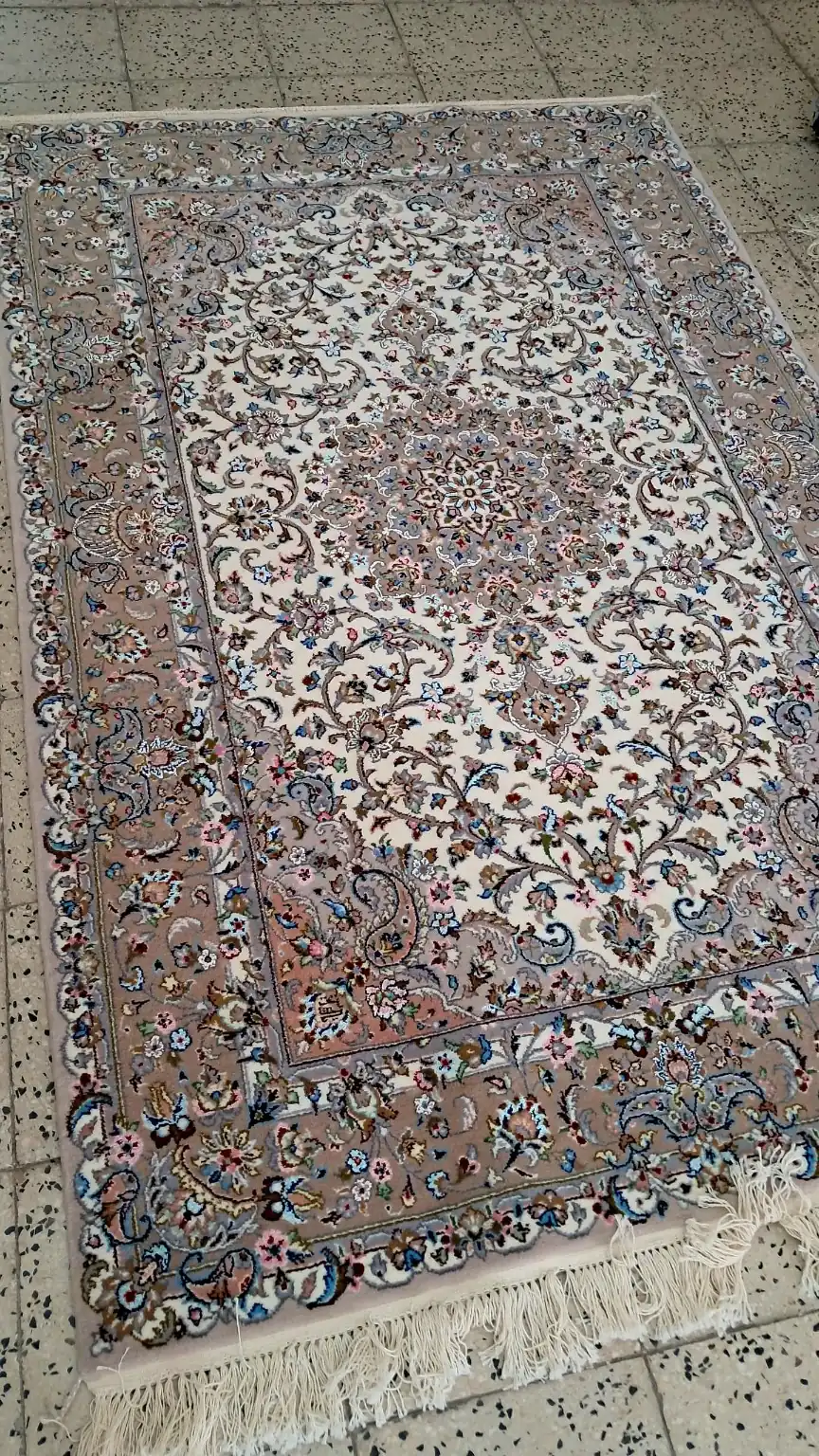 Detailed angled view of the silk floral motifs and medallion on Sacred Lachak Toranj Kashan carpet