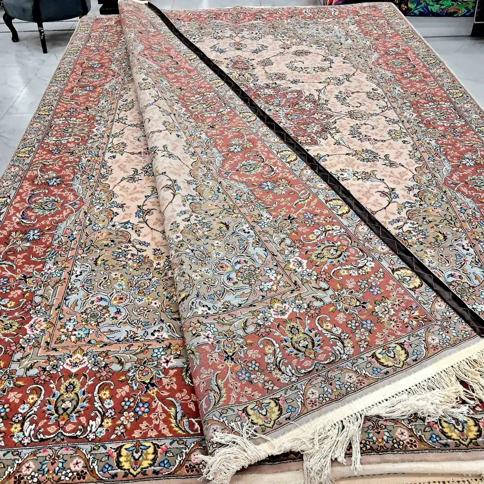 Folded detail view of PRR-KH-031 showing silk-highlighted floral motifs, peach field and rust-red border