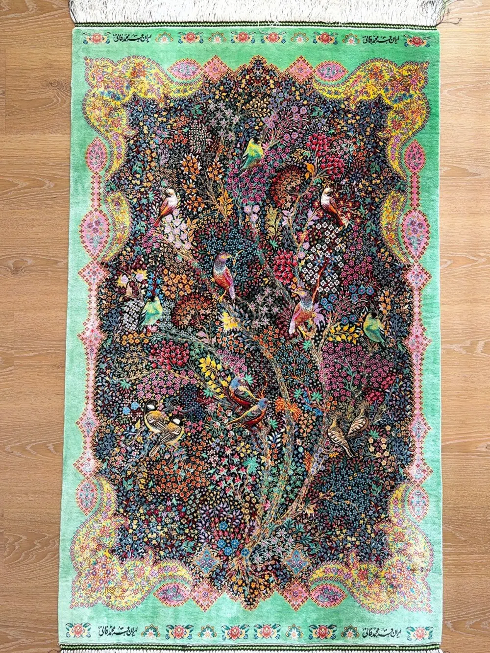 Emerald Aviary of Blossoms handmade Qom pure silk carpet with colourful birds and a dense Gol-o-Bolbol garden — detail 1
