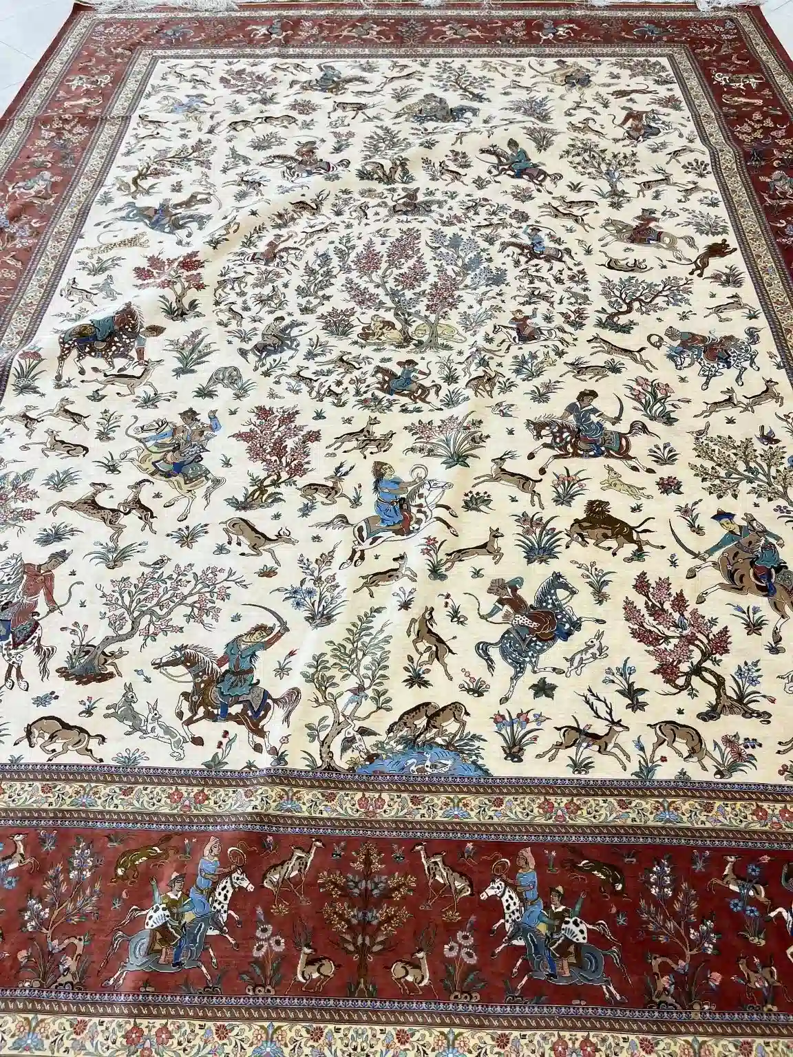 Ivory Grand Royal Hunt handmade Qom pure silk carpet featuring a monumental courtly hunting panorama with mounted figures, animals and flowering trees