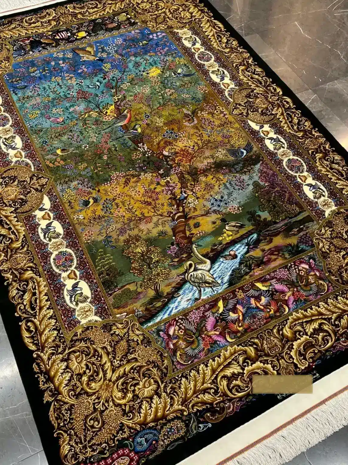 Golden Paradise of Birds handmade Qom pure silk carpet featuring a painterly paradise garden alive with birds, blossoms, water and a sculptural golden border